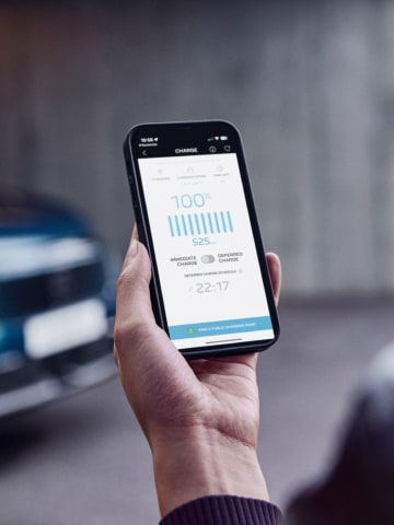 Vrouw met een smartphone voor de PEUGEOT E-3008 Dual Motor