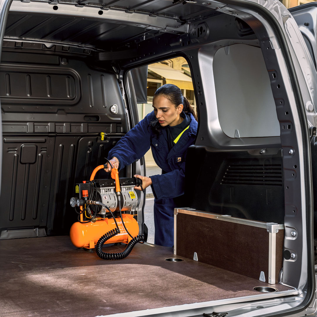 Woman loading a PEUGEOT E-Partner through the rear doors